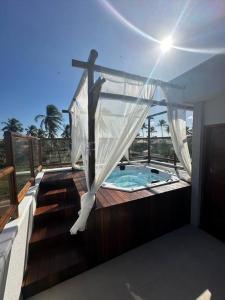 a house with a bath tub with a cross on a balcony at Villa Palmeira Flecheiras 202 in Flecheiras