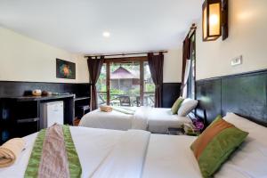 a hotel room with two beds and a window at Mook Lanta Eco Resort in Ko Lanta