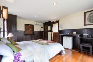 a bedroom with a large white bed and a desk at Mook Lanta Eco Resort in Ko Lanta