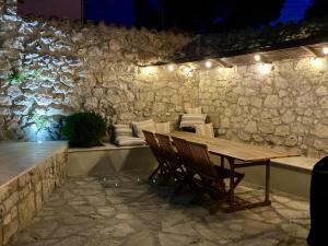 a wooden table and chairs in a room with a stone wall at Maison en pierre avec piscine, 6 couchages, située au cœur de Mallemort, Provence. - FR-1-658-25 in Mallemort