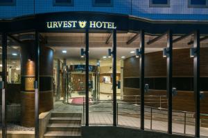 東京にあるUrvest Hotel Kamataの目に見えないホテルを読む看板のあるホテルの入り口