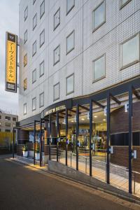 a large building with a sign for a hotel at Urvest Hotel Kamata in Tokyo