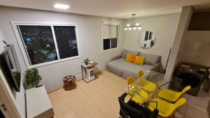 a living room with a table and yellow chairs at Aconchegante Apartamento no coração de Santo Amaro in Sao Paulo