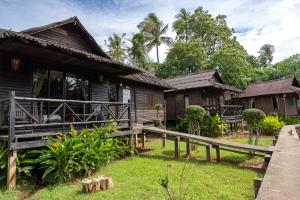 a house with a wooden fence in front of it at Mook Lanta Eco Resort in Ko Lanta