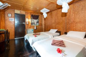 Habitación con 3 camas con flores. en Mook Lanta Eco Resort, en Ko Lanta