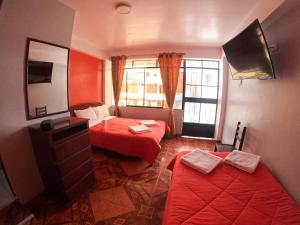 een kleine kamer met 2 bedden en een spiegel bij Hospedaje Piura in Oxapampa