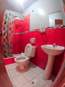 een rode badkamer met een toilet en een wastafel bij Hospedaje Piura in Oxapampa