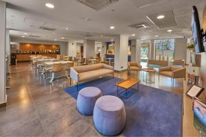 a lobby of a hospital with tables and chairs at City Express by Marriott Irapuato in Irapuato
