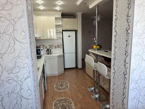 a kitchen with a white refrigerator and a table at Квартира посуточно in Shymkent