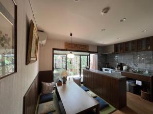 a kitchen with a table and a dining room at Imakumano Terrace - Mokubei An 木米庵 in Kyoto