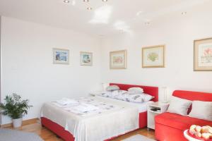 - une chambre avec un lit et un canapé rouge dans l'établissement Amanda Apartment, à Zagreb