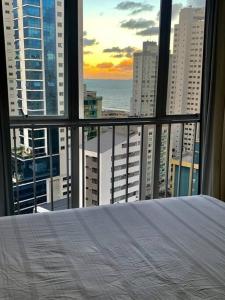 a bedroom with a view of the ocean from a window at Apartamento em Balneário com vista para o mar in Balneário Camboriú