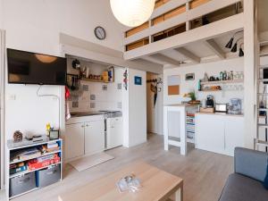 una cucina con mobili bianchi e un tavolo in una stanza di Appartement 4 pers avec WIFI, animaux admis, parking privé - FR-1-409-142 a Narbonne