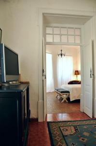 a living room with a television and a bedroom at Casa18.55 - Time with history in São Brás de Alportel