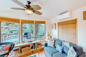 uma sala de estar com um sofá azul e janelas em Whimsical Whaleshead, OV10 em Carpenterville