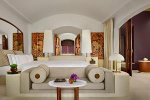a bedroom with a large bed with a couch and a table at Phulay Bay, A Ritz-Carlton Reserve in Tab Kaek Beach