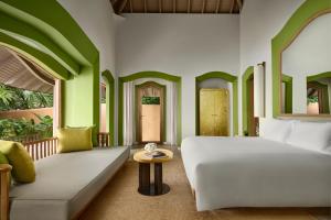 a bedroom with a bed and a couch and a table at Phulay Bay, A Ritz-Carlton Reserve in Tab Kaek Beach