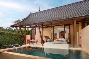 a villa with a swimming pool next to a house at Phulay Bay, A Ritz-Carlton Reserve in Tab Kaek Beach