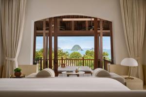 a bedroom with a bed and a large window at Phulay Bay, A Ritz-Carlton Reserve in Tab Kaek Beach