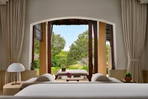 a bedroom with two beds and a large window at Phulay Bay, A Ritz-Carlton Reserve in Tab Kaek Beach
