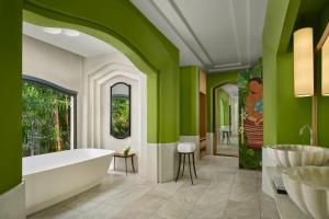 a bathroom with a tub and green walls at Phulay Bay, A Ritz-Carlton Reserve in Tab Kaek Beach