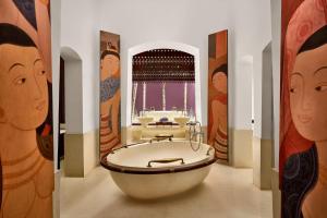 a bathroom with a large tub in a room with paintings at Phulay Bay, A Ritz-Carlton Reserve in Tab Kaek Beach