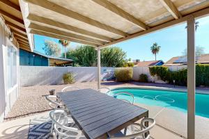 a patio with a table and chairs next to a swimming pool at Grand Palms in Scottsdale