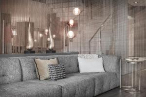 a living room with a gray couch with pillows at AC Hotel by Marriott Alicante in Alicante
