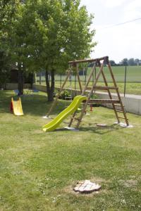 a playground with a slide in a park at Logis - Hôtel & Restaurant Moulin Des Forges in Saint-Omer-en-Chaussée