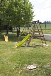 - une aire de jeux avec toboggan dans un parc dans l'établissement Logis - Hôtel & Restaurant Moulin Des Forges, à Saint-Omer-en-Chaussée