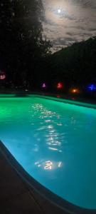 una piscina di acqua verde di notte di Casa con piscina mena a Los Andes
