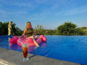 a woman sitting on an inflatable raft in a swimming pool at Innora Jungle Resort And Spa in Nusa Penida