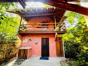 a small house with a balcony on top of it at ITCHIMBIA GARDEN AYAMPE Montaña y Mar in Ayampe