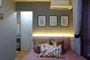 AnnaHome122@Latkrabang في Ban Khlong Prawet: غرفة نوم مع سرير وردي مع بعض الوسائد