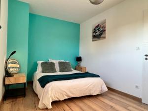 um quarto com uma cama com uma parede azul em Maison Saint-Brevin-les-Pins, 4 pièces, 6 personnes - FR-1-364-166 em Saint-Brévin-les-Pins
