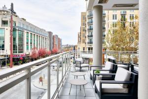 einen Balkon mit Stühlen und Tischen in einer Stadtstraße in der Unterkunft AC Hotel National Harbor Washington, DC Area in National Harbor