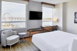 una camera d'albergo con letto, scrivania e finestra di AC Hotel National Harbor Washington, DC Area a National Harbor