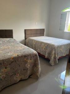 2 camas en una habitación blanca con aceras en Sitio Igarapé, en Igarapé