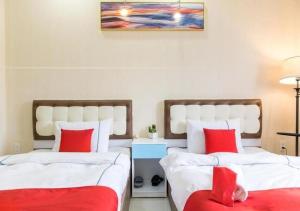 Duas camas com almofadas vermelhas num quarto em Bro Hotel 45-47 Song Hành, Quận 6 - by Bay Luxury em Ho Chi Minh