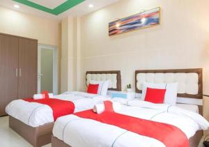 duas camas num quarto com lençóis vermelhos e brancos em Bro Hotel 45-47 Song Hành, Quận 6 - by Bay Luxury em Ho Chi Minh