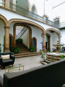 a lobby with a staircase and a fountain at Markee Hotel Boutique Querétaro Centro Historico in Querétaro