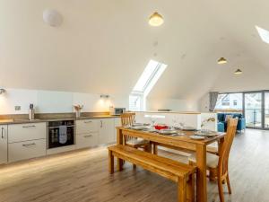 a kitchen and dining room with a wooden table and chairs at 4 bed in Westward Ho 77913 in Northam