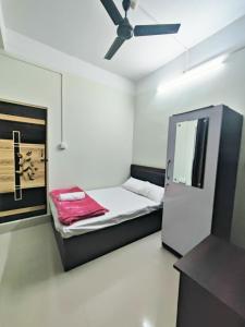 um pequeno quarto com uma cama e uma ventoinha de tecto em JM Suites em Tezpur