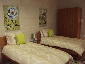 a bedroom with two beds with green pillows at House Valletta in Valletta