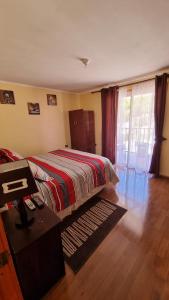 een slaapkamer met een bed, een tafel en een raam bij Departamento Puclaro in Vicuña