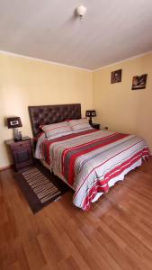 1 dormitorio con 1 cama grande y suelo de madera en Departamento Puclaro en Vicuña