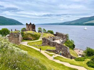 a castle on the shore of a body of water at 2 Bed in Loch Ness GRANY in Invermoriston
