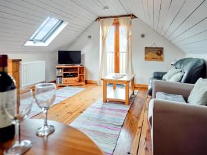 a living room with a couch and a table at Mill Meadow Cottage in East Down