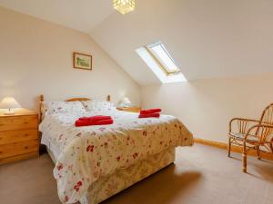 - une chambre avec un lit doté d'oreillers rouges dans l'établissement 2 Bed in Helmsley TGCHF, à Chop Gate