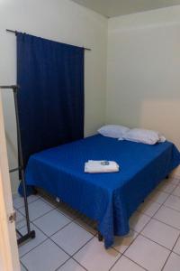 um quarto com uma cama azul com toalhas em Villa La Casita em Santa Ana